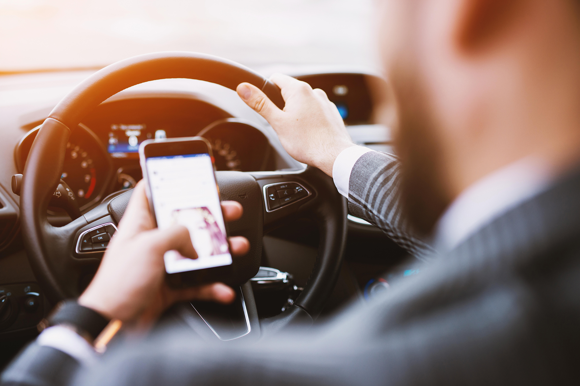 Man Driving While Holding Cellphone